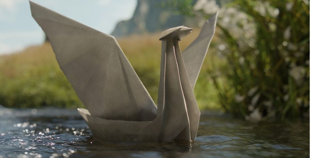 An origami swan which floats (sails) on a stream with a beautiful grassy, hilly background behind