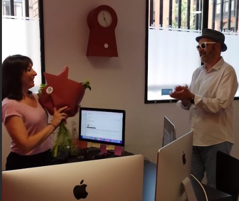 Alma celebra sus 20 años en Cálamo & Cran con un ramo de flores mientras Antonio Martín aplaude. 