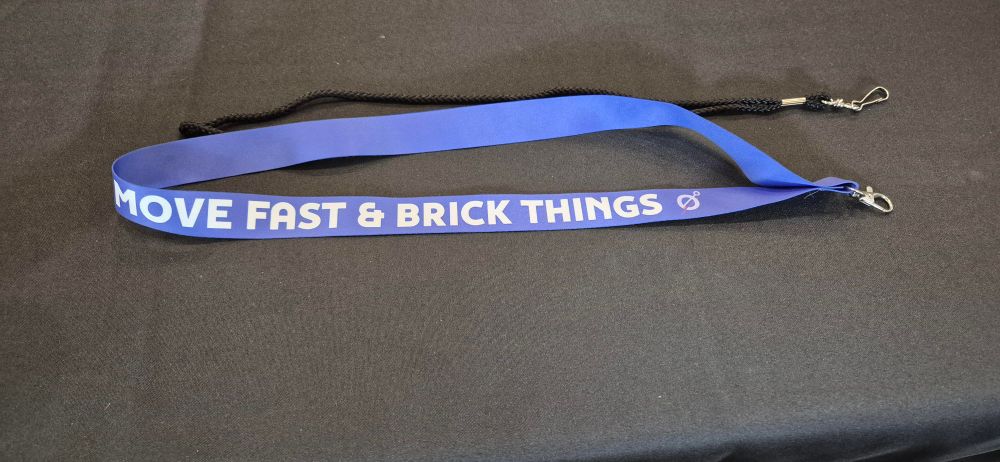 Blue lanyard with lettering reading "MOVE FAST AND BRICK THINGS"