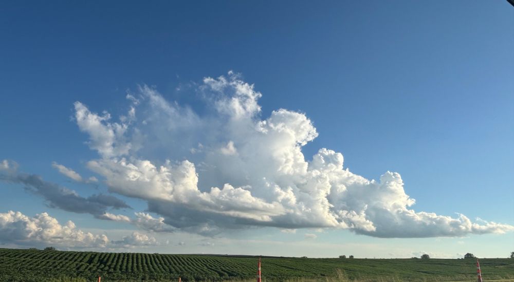 Beautiful cloud formation in a blue sky over a green field