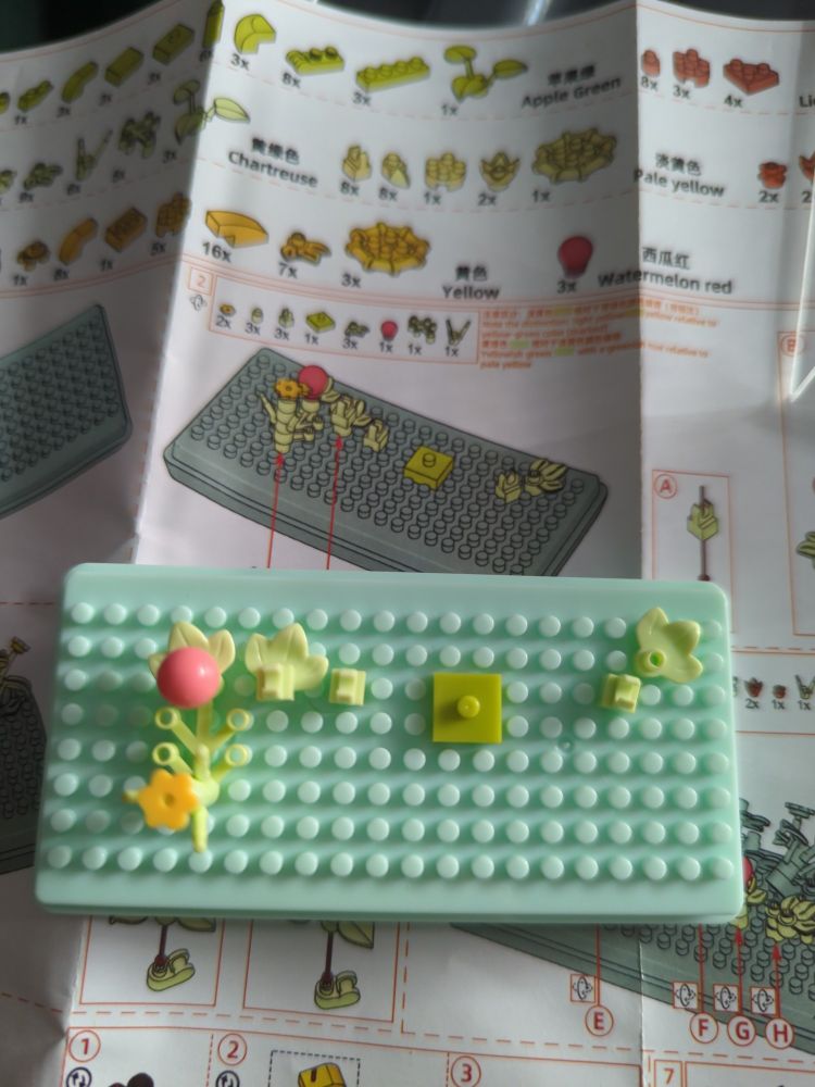 A few small pieces attached to the mint green base. In the background are the instructions.