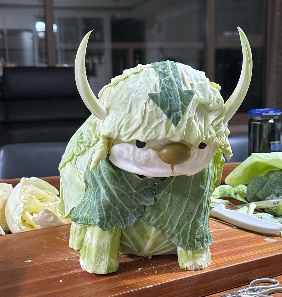 a head of napa cabbage styled to look like appa from avatar the last airbender, a mythical flying water bison with an arrow on its head