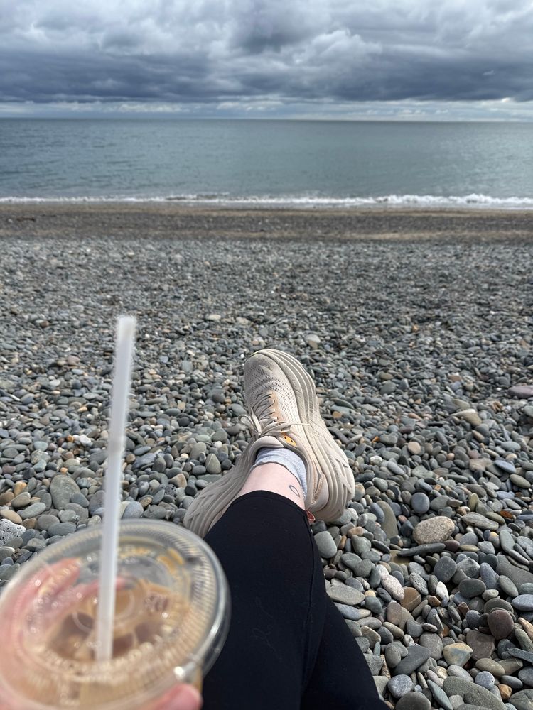 Sitting on a rocky beach with an iced latte, looking out at the Irish Sea under dark clouds
