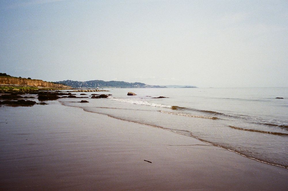 Beach on a hazy day, looking toward cliffs and coastline in the distance