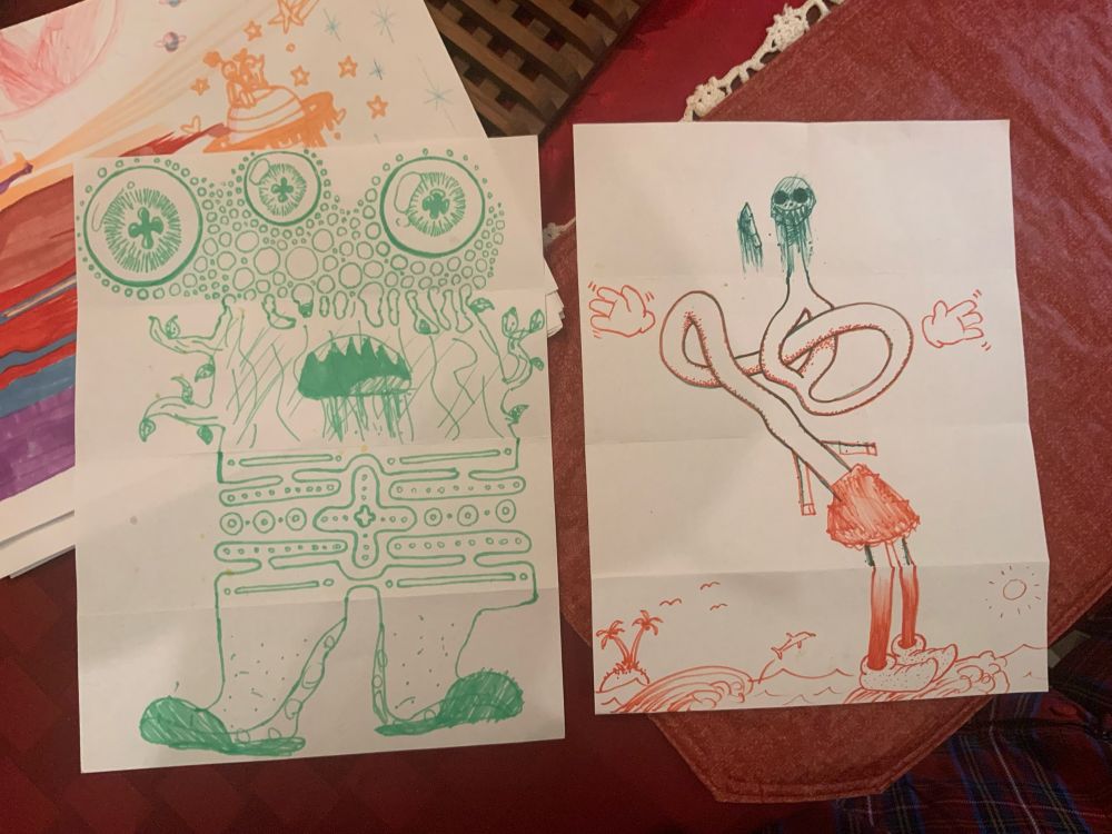 Two pieces of white paper. One has a green monster with three eyes a body that is half tree with mouth and half weird pattern that looks a bit like a pac man game grid and thick ankles/feet wearing house slippers. The other drawing is of a weird long bendy loopy being with a terrifying skull head and disembodied gloved hands. It is wearing a red skirt and cartoon elf shoes and seems to be standing on an ocean wave