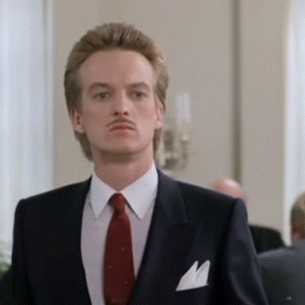 a man in a suit with a red tie and a pocket square