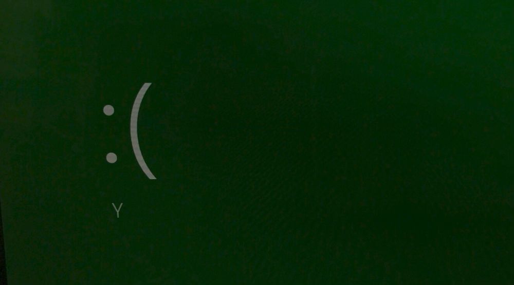 An image of a stop error showing the emoticon and the letter Y on a green background.