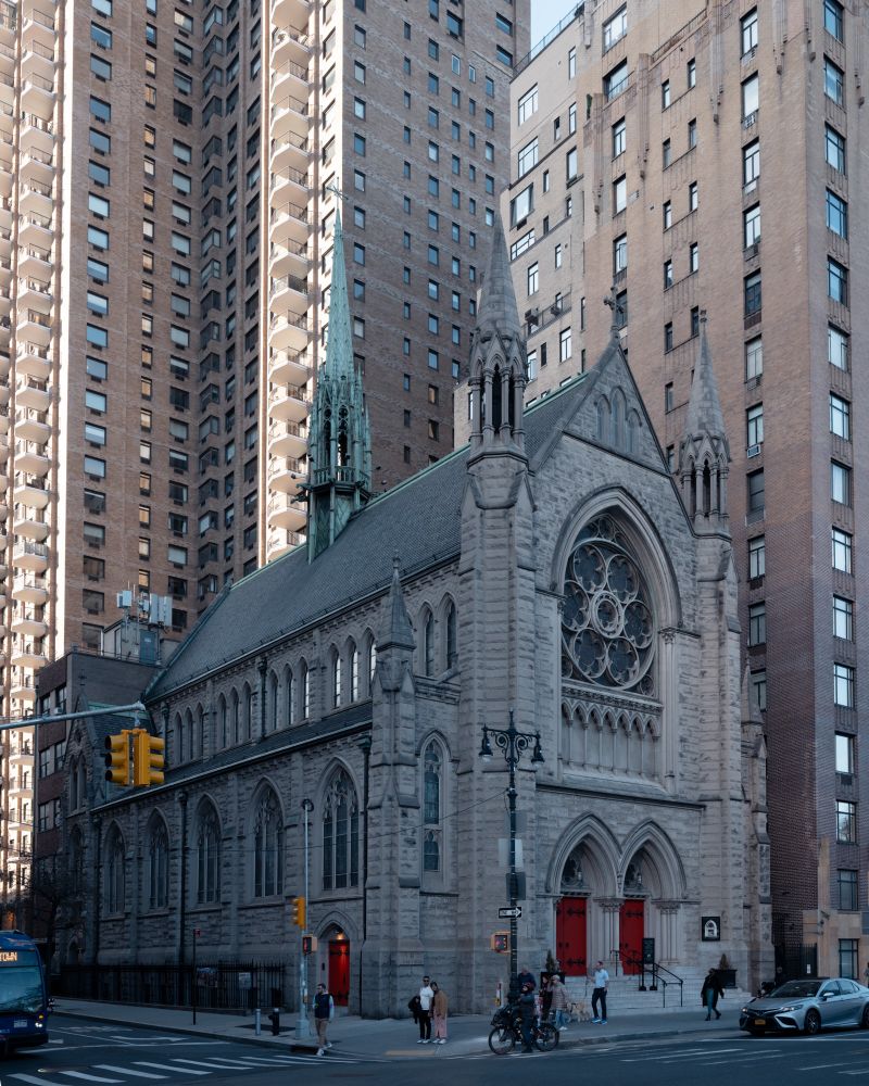 Photo of the Gothic Revival Holy Trinity Lutheran church with modern multistory apartment buildings in the background