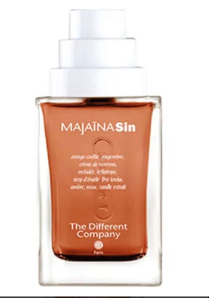 Bottle of Majaina Sin by the different company, with tan colored perfume juice and the notes in French and a white cap that looks like a Devo hat 