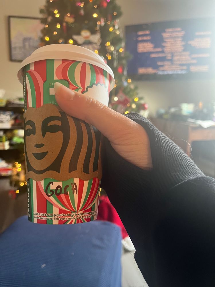 A holiday Starbucks cup with “GOCH” written on it, which means red in Welsh. My Christmas tree is in the background.