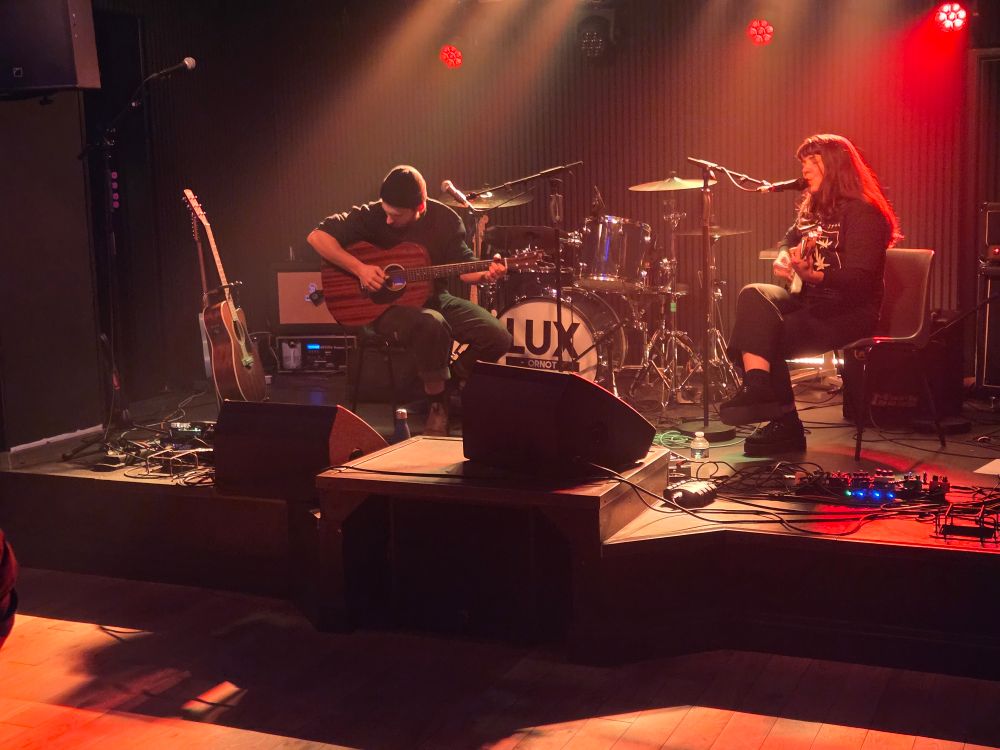 Sur la nouvelle scène du Fury Défendu à Rouen. Le public reste près du bar. Lumière rougeoyante et parquet court au sol