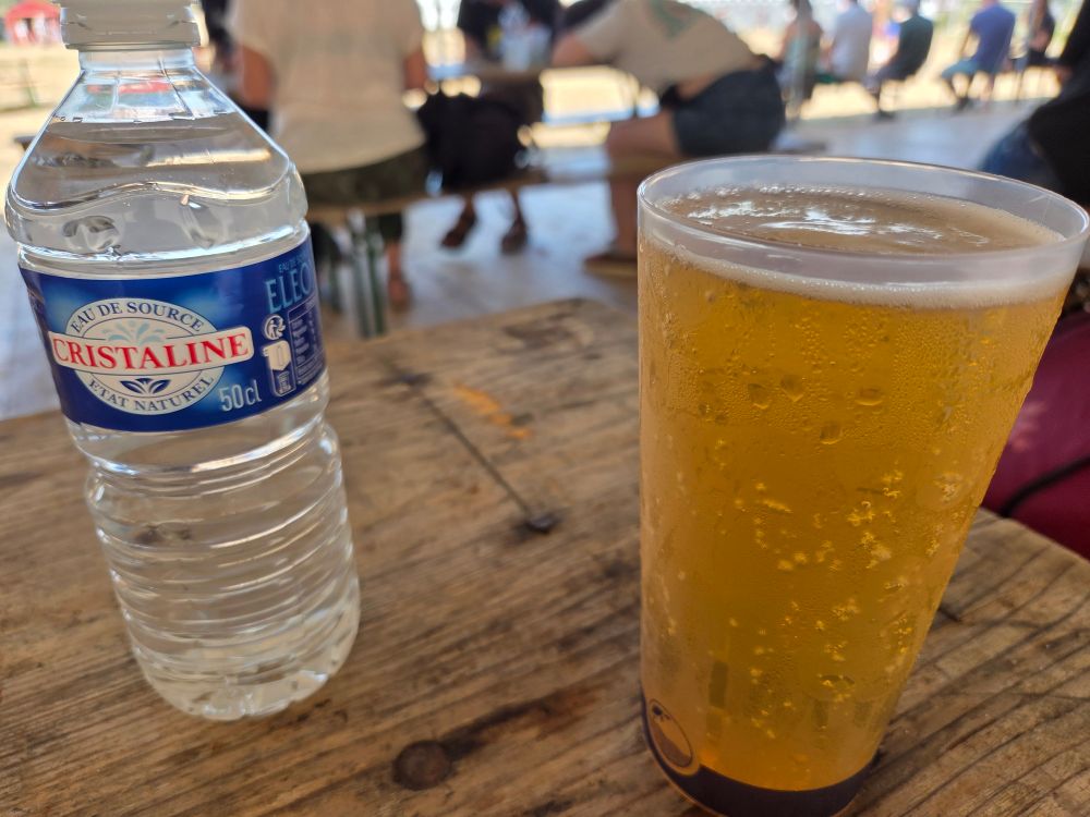 Pinte d'eau et pinte de bière, les deux font la paire, sur une table dans le bar du camping de la route du rock 