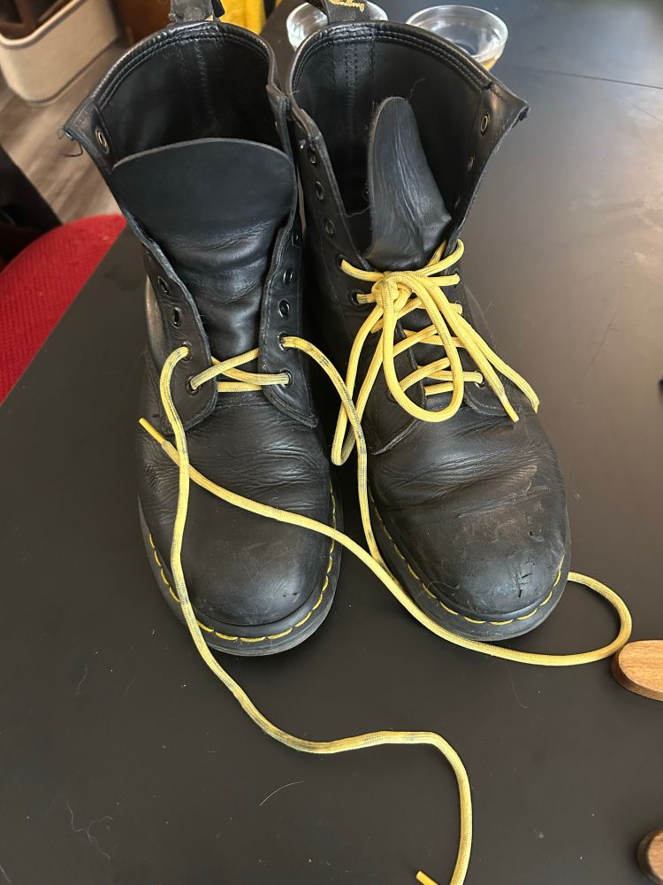 jess’s black leather boots, in need of some TLC. The yellow laces are partially removed. 
