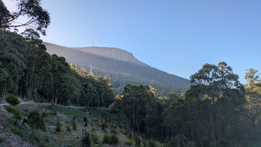 A view of kunanyi / Mt Wellington with rays of sunlight beaming down at sunset