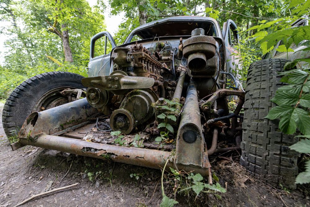 Old rusty car the engine is still there and clearly visible 