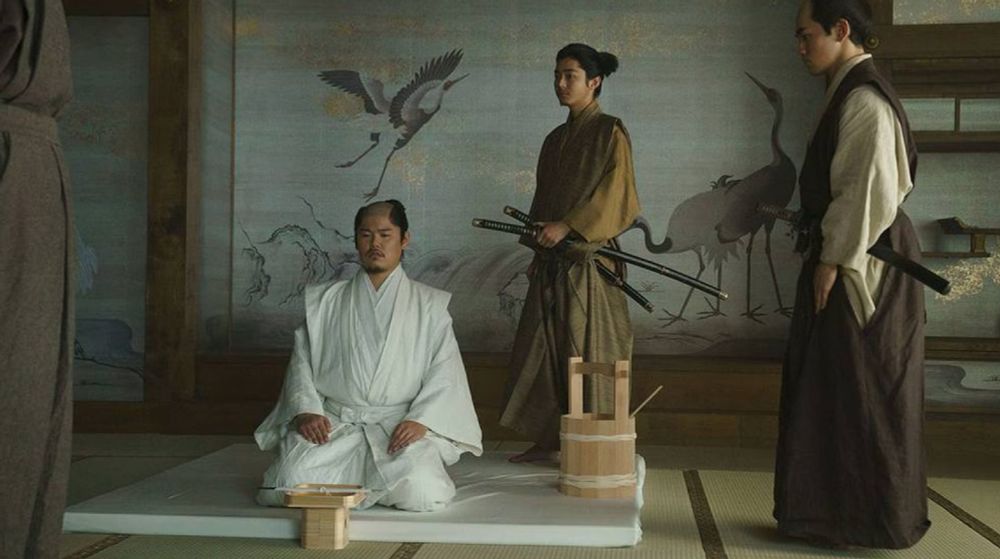 shot from the show shogun where a man prepares to commit seppuku with his second stood behind him