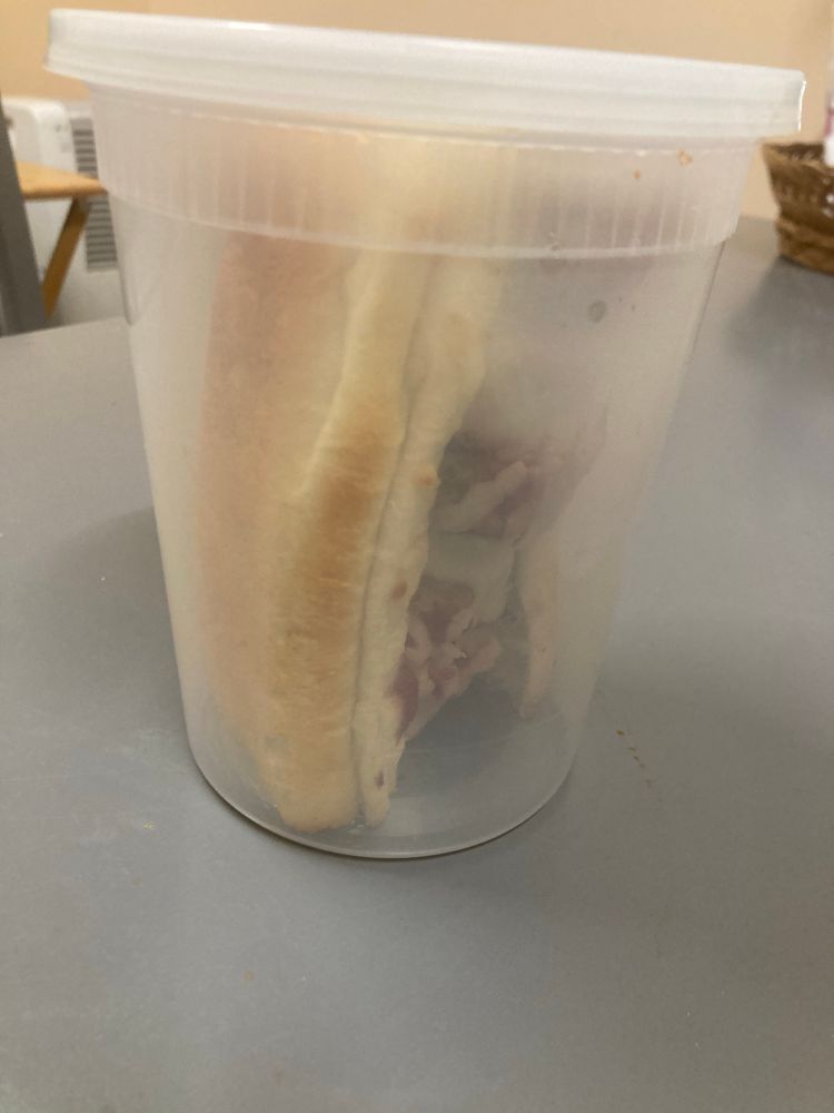 half a meatball sub in a deli container