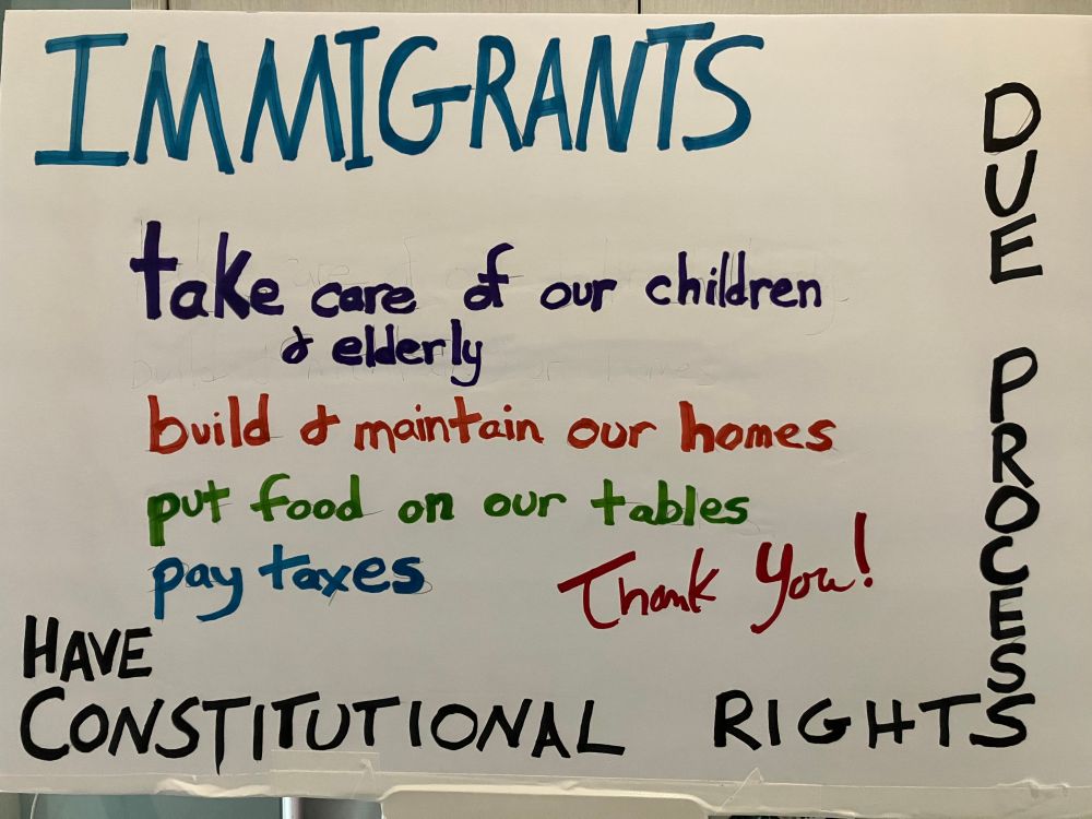 Sign made for International Workers' Day on May 1, 2025. Text reads: Immigrants take care of our children & elderly, build and maintain our homes, put food on our tables, pay taxes. Thank you." Border text: Have constitutional rights due process"