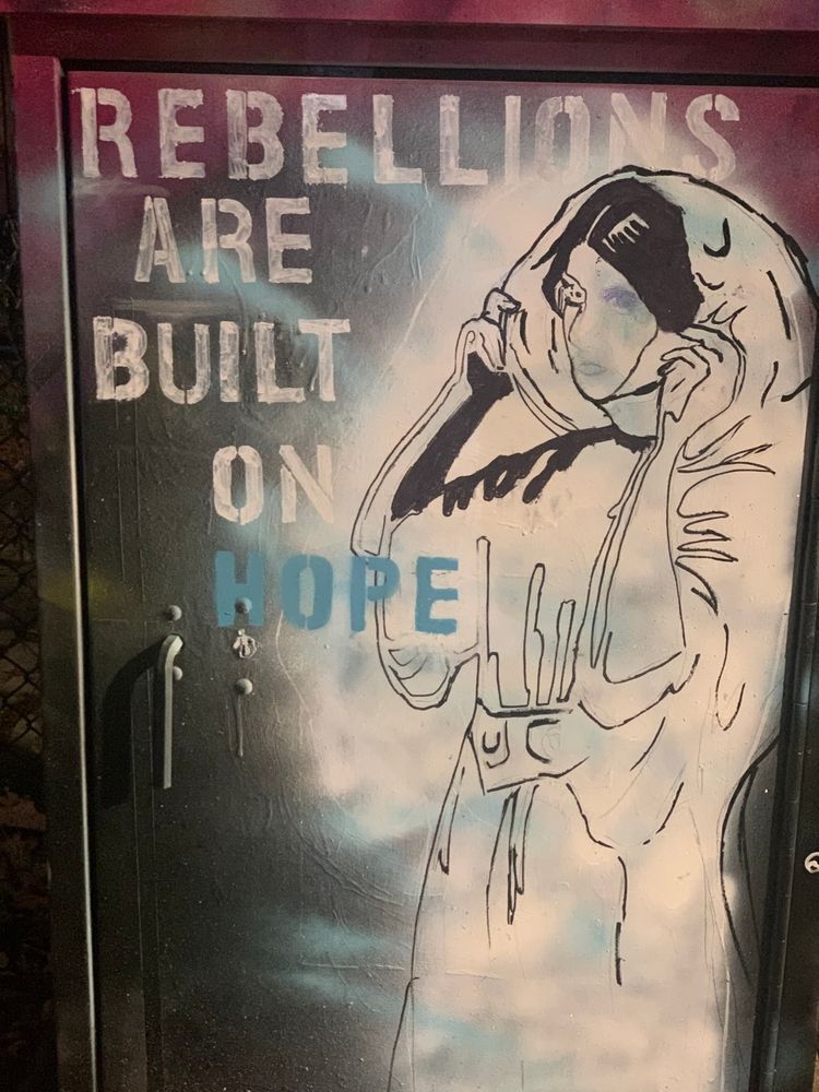 #Rebellions are built on hope” stencil letters over artwork that appears to be inspired by Star Wars