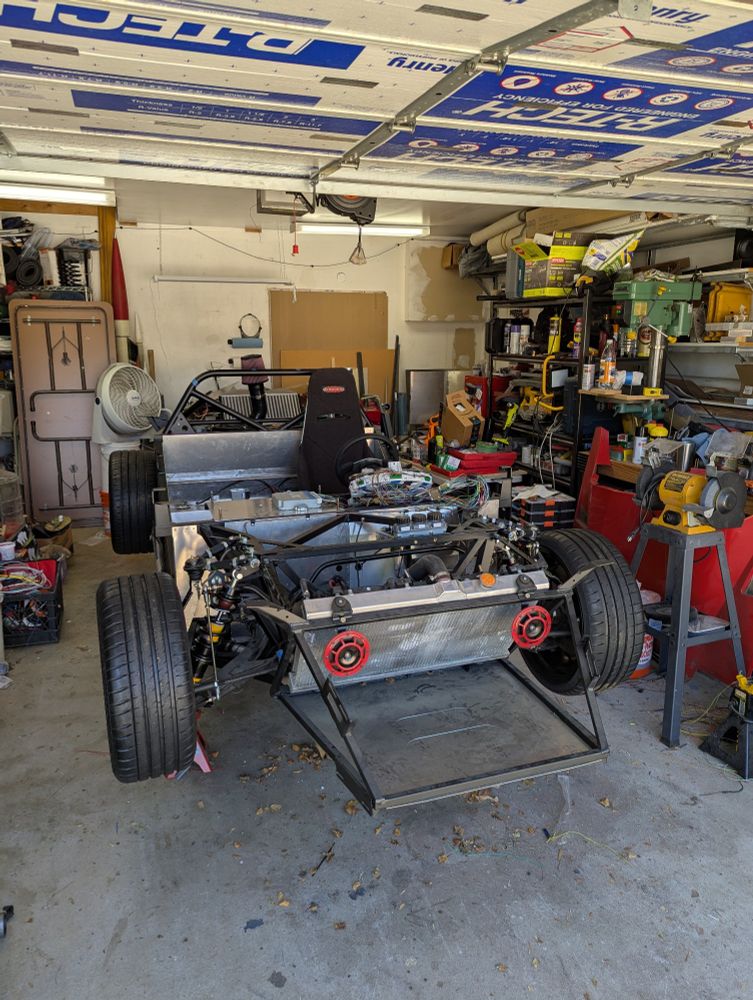 A car frame, without a body, on jack stands.