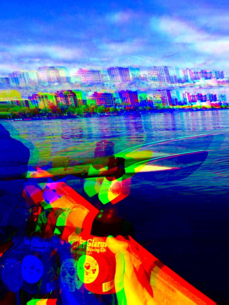 An RGB shifted image of a new Glarus raspberry tart beer in a kayak in front of the Madison Wisconsin waterfront 
