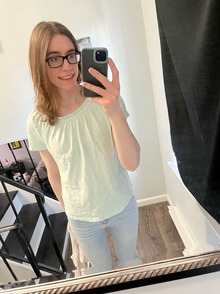 White trans girl takin a selfie. Mint shirt with light blue jeans