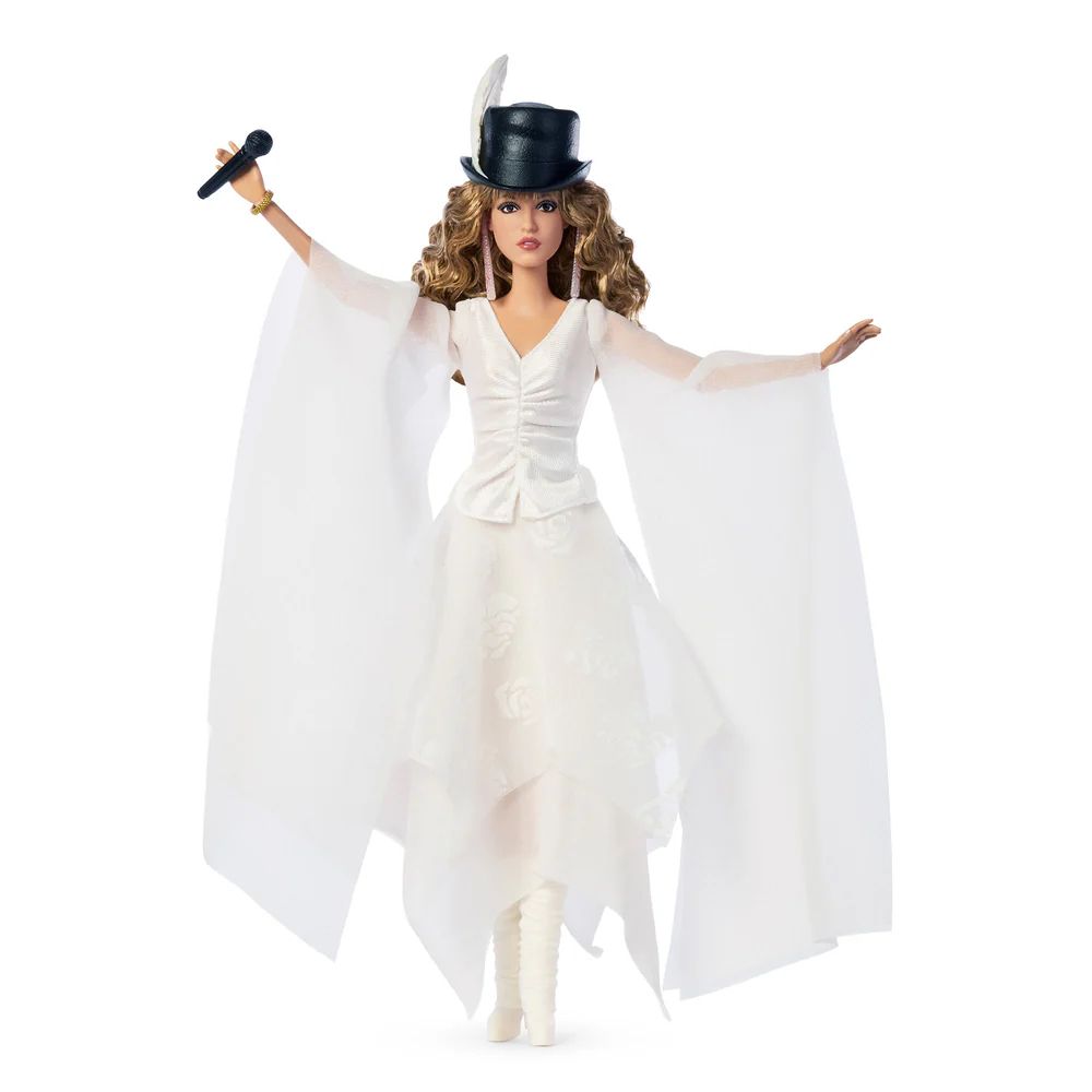 A Barbie doll dressed in white wearing a top hat and holding a microphone 