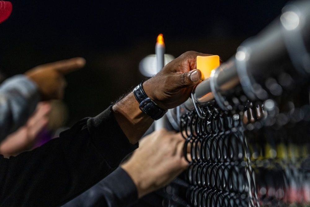 The Church of Jesus Christ of Latter-day Saints Bishop Chris Barnes holds an electric candle during the Grand Blanc Better Together community gathering held at Grand Blanc High School’s Don Batchelor Field on Tuesday, Oct. 7, 2025. The community came together following the Sept. 28 mass shooting at The Church of Jesus Christ of Latter-day Saints in Grand Blanc Township that left four churchgoers dead and eight people injured as well as the shooter killed by police on scene. Photo by Ryan Garza, Detroit Free Press