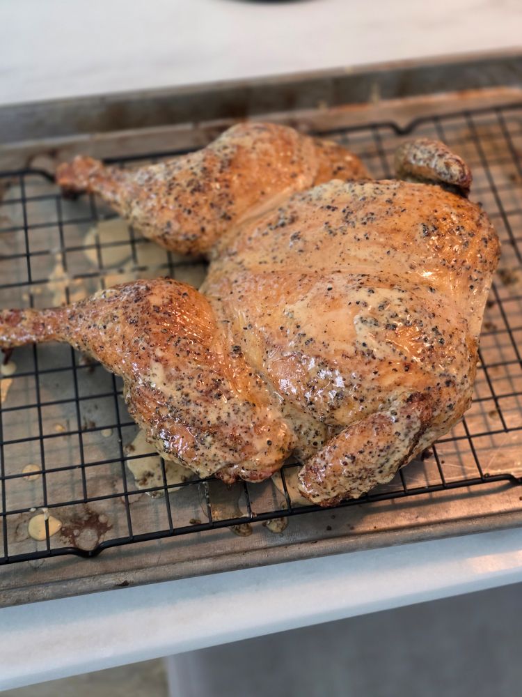 A picture of a smoked chicken seasoned with Meat Church Holy Cow rub and dipped in a modified Alabama white sauce.