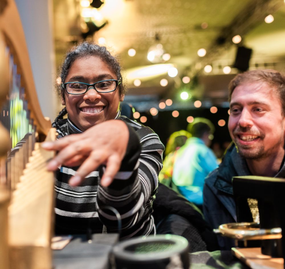 An OrchLab participant smiles as they play the Touch Harp 
