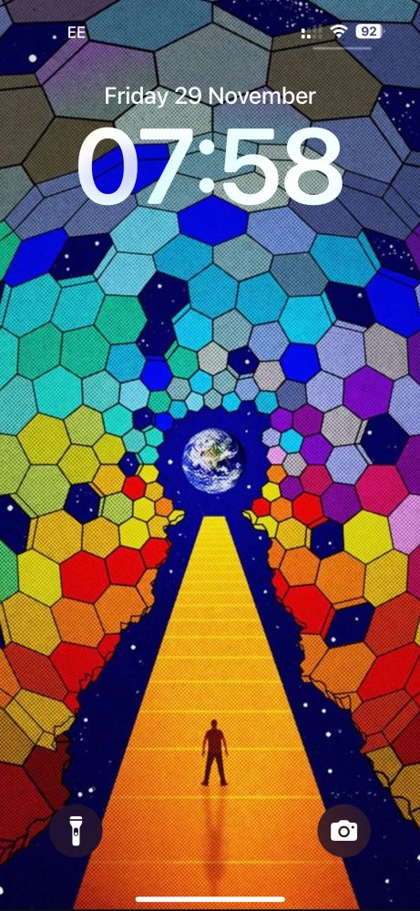 A man stands on a golden pat, facing toward the earth. He is surrounded by multicoloured hexagons, forming a tunnel. There’s a gap either side of the path and some hexagons missing where you can see an inky blue sky with stars.