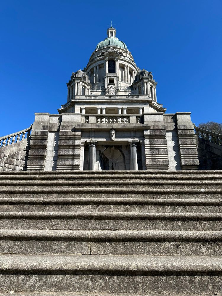 A view of the Ashton Memorial in Lancaster from the fountain steps. Bright blue, cloudless shy behind 