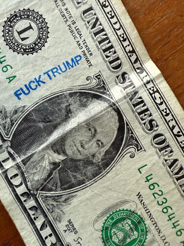 Dollar bill with Fuck Trump stamp