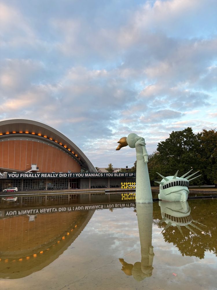 Installation im Wasserbecken vor dem Haus der Kulturen der Welt: der riesige Kopf einer aufblasbaren Freiheitsstatue ragt gerade so aus dem Wasser.