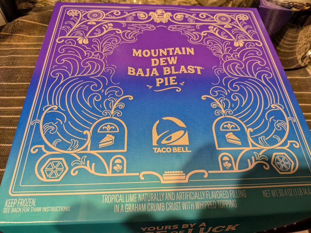A colorful pie box that reads: Mountain Dew Baja Blast Pie from Taco Bell