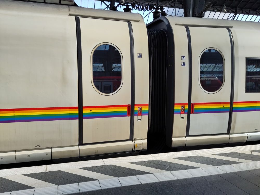 Picture of a German ICE train with an horizontal Rainbow stripe.