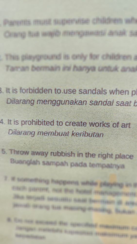 A signage that shows the English translation of "Dilarang membuat keributan" as "It is prohibited to create works of art". The correct translation should be "Do not create ruckus/noise".
