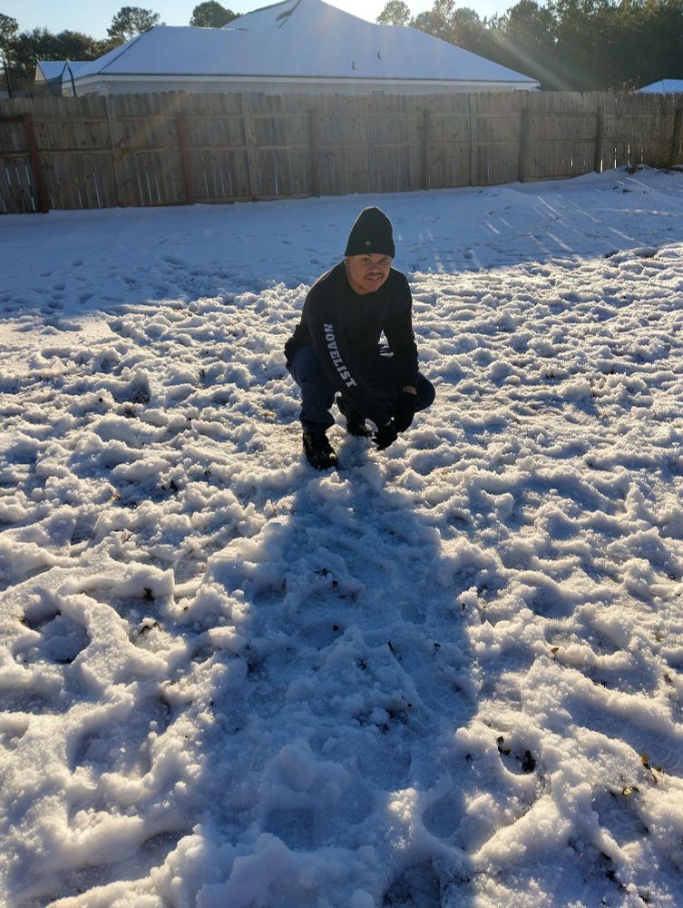 Boy squats in snow