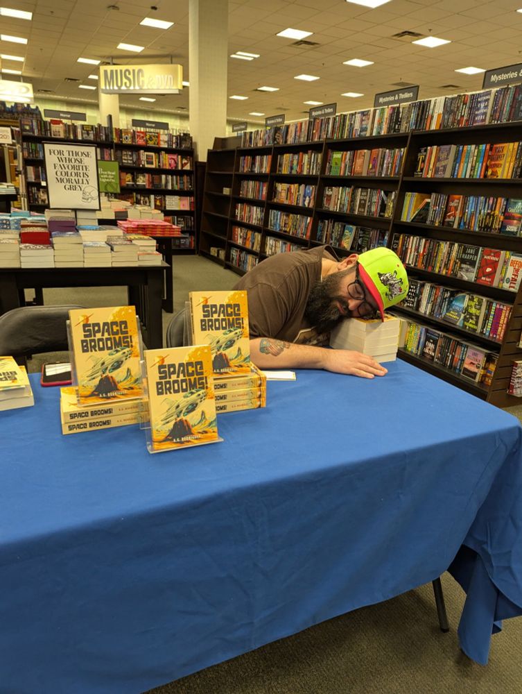 Me, the author, exhausted after the signing, sleeping on a pile of Space Brooms! 