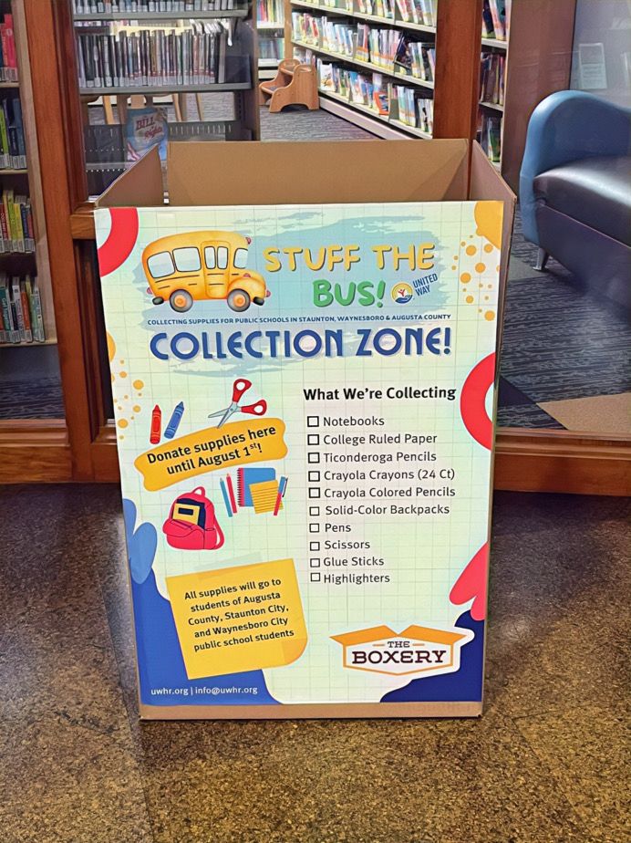 Photo of the “Stuff the Bus” collection box in the library. The Boxery logo. The United Way logo. Text that reads: Stuff the bus! Collection Zone. Donate supplies here until August 1st! All supplies will go to students of Augusta County, Staunton City, and Waynesboro City public school students. What were collecting: Notebooks, College ruled paper, Ticonderoga pencils, Crayola Crayons (24 Ct), Crayola Colored pencils, Solid-colored backpacks, Pens, Scissors, Glue Sticks, and Higlighters. 