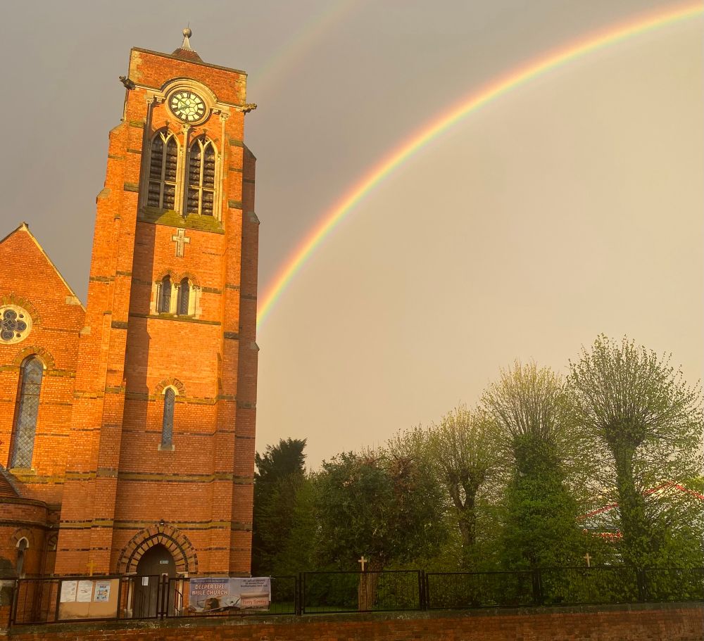 A modern redbrick church with a rainbow behind it in depressed Midlands town Northampton. 