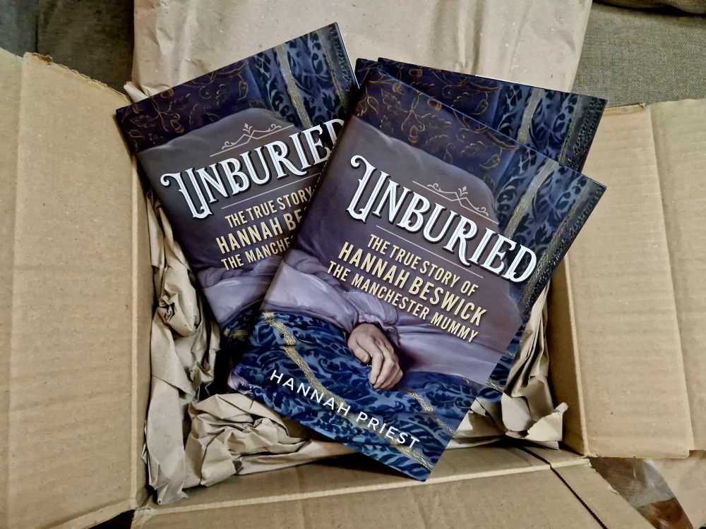 A box of books. Each one is a copy of Unburied: The True Story of Hannah Beswick, the Manchester Mummy by Hannah Priest