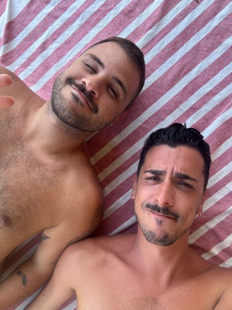 Dani y yo tumbados sobre una toalla de rayas 