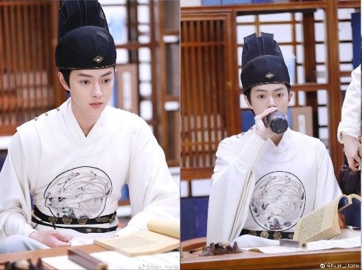 Taiwanese actor Chen Kuan-Hung dressed in the costume for the role of Tang Fan in the cdrama Sleuth of the Ming Dynasty, staring off into the distance before taking a swing of what looks like a baijiu bottle