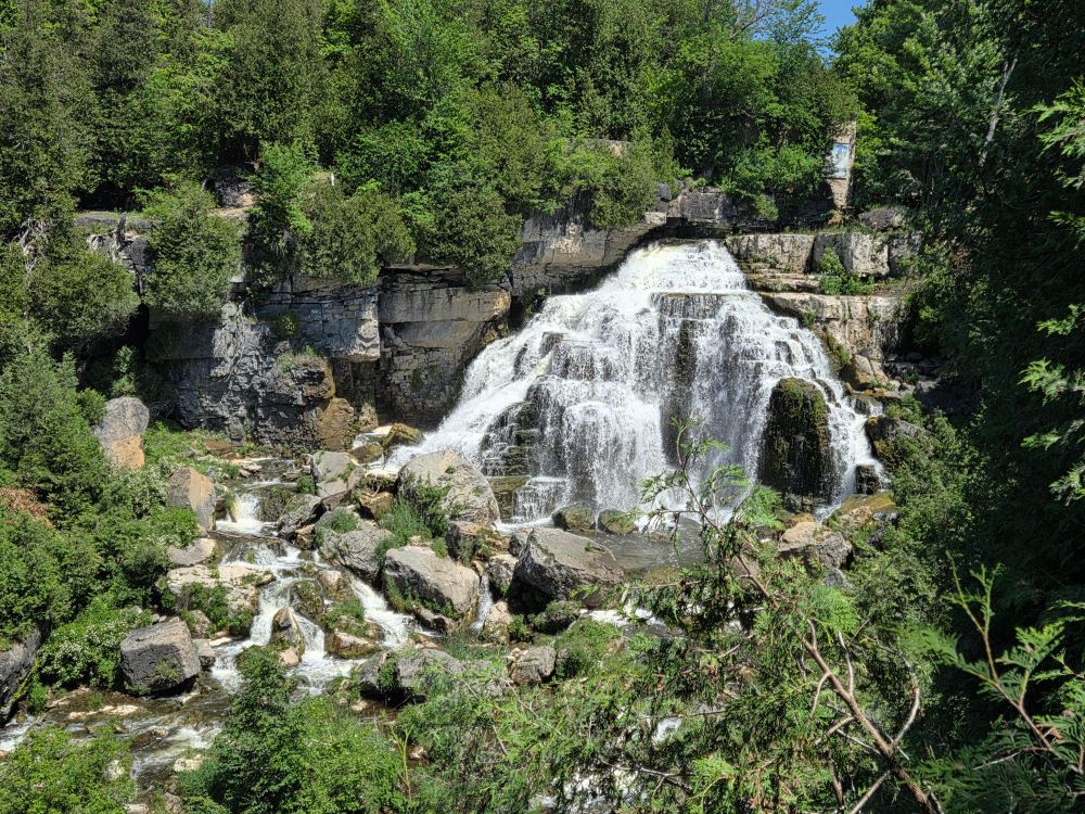 A waterfall seen at a distance on a sunny summer day.
