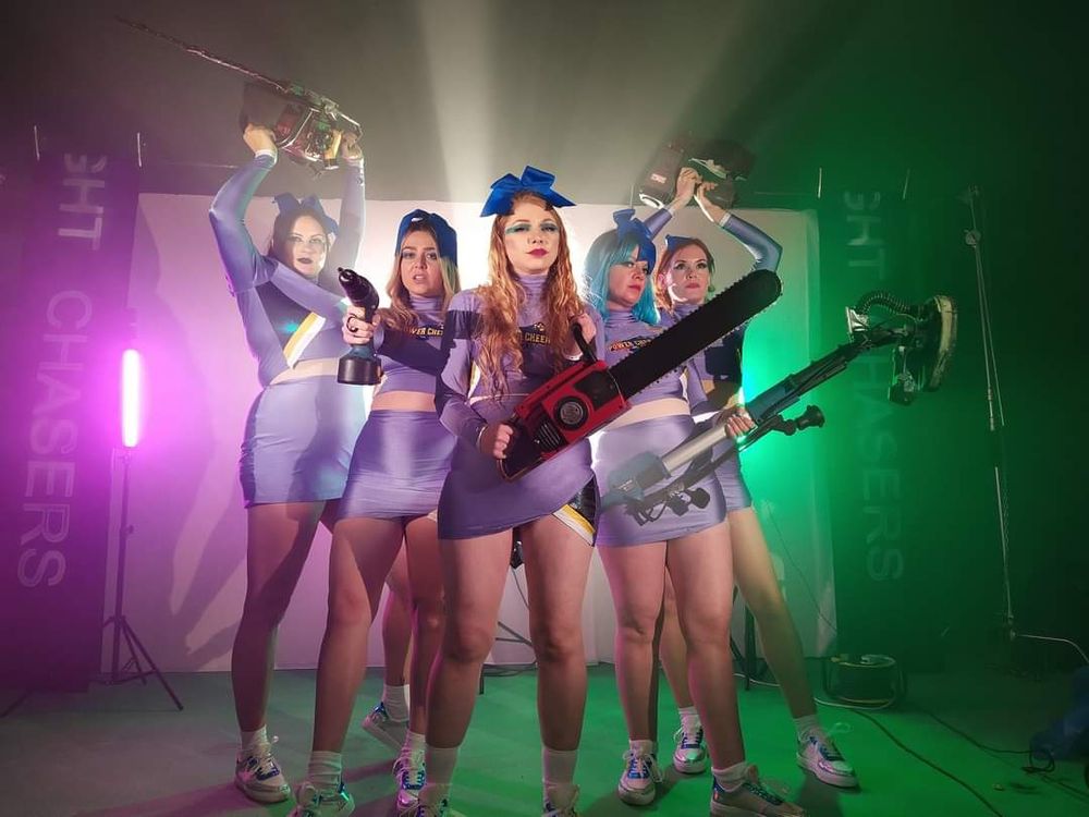 Cheerleaders carrying powertools I'm brightly coloured lighting