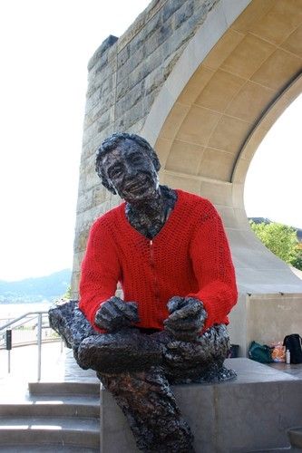 A bronze statue of Fred (Mr.) Rogers wearing a red sweater.