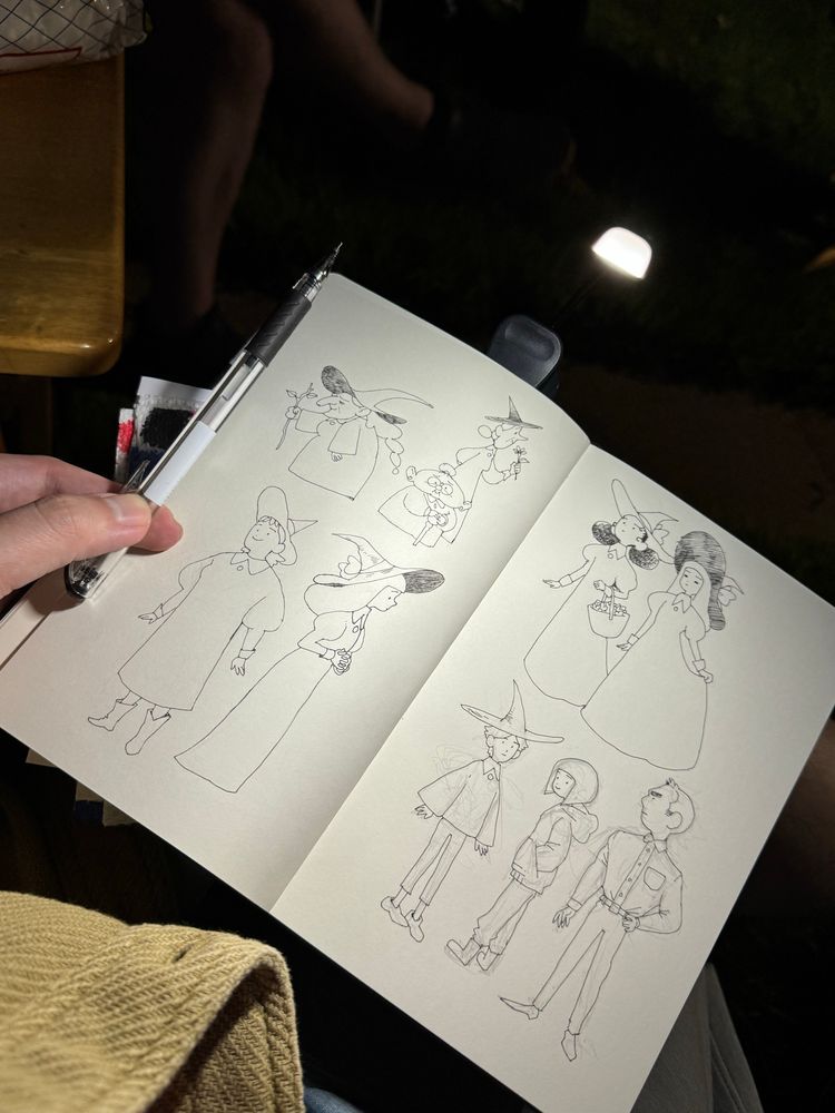 A small clip-on light illuminates the pages of a sketchbook on my lap in the dark. 