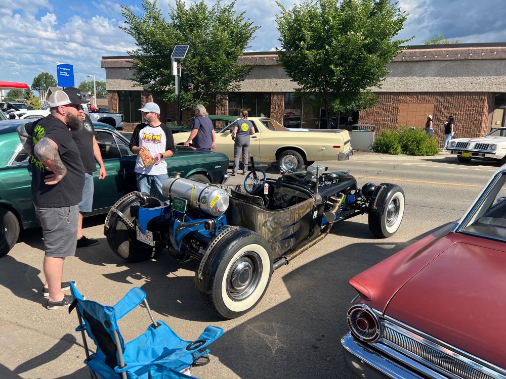 Hot rod with a bunch of guys hanging out
