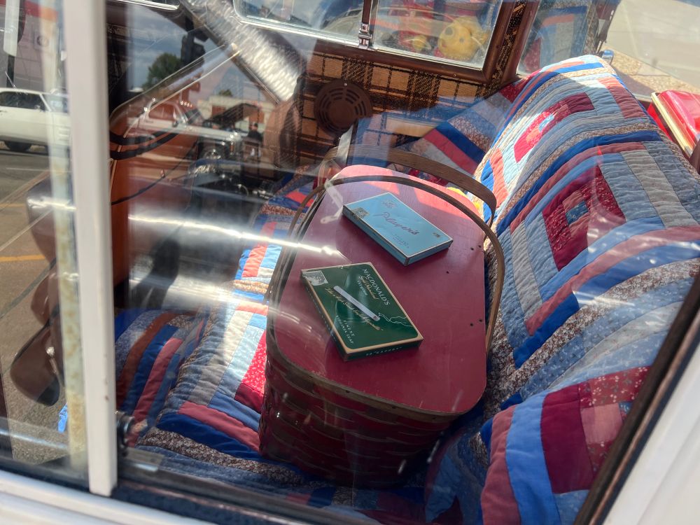 Back seat of the Escort with antique Players and Export A cigarette packages sitting on top of the picnic basket